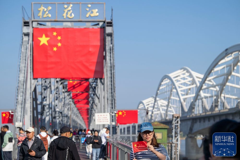 ↑ 10月1日,游客在哈尔滨市滨州铁路桥上游览。新华社记者 张涛 摄