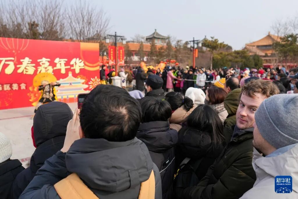 来自美国的游客欣赏川剧变脸表演。