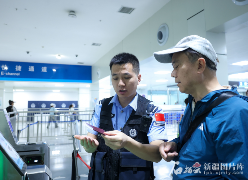 6月3日，霍尔果斯出入境边防检查站执勤民警引导游客通过快捷通道。曹荣摄