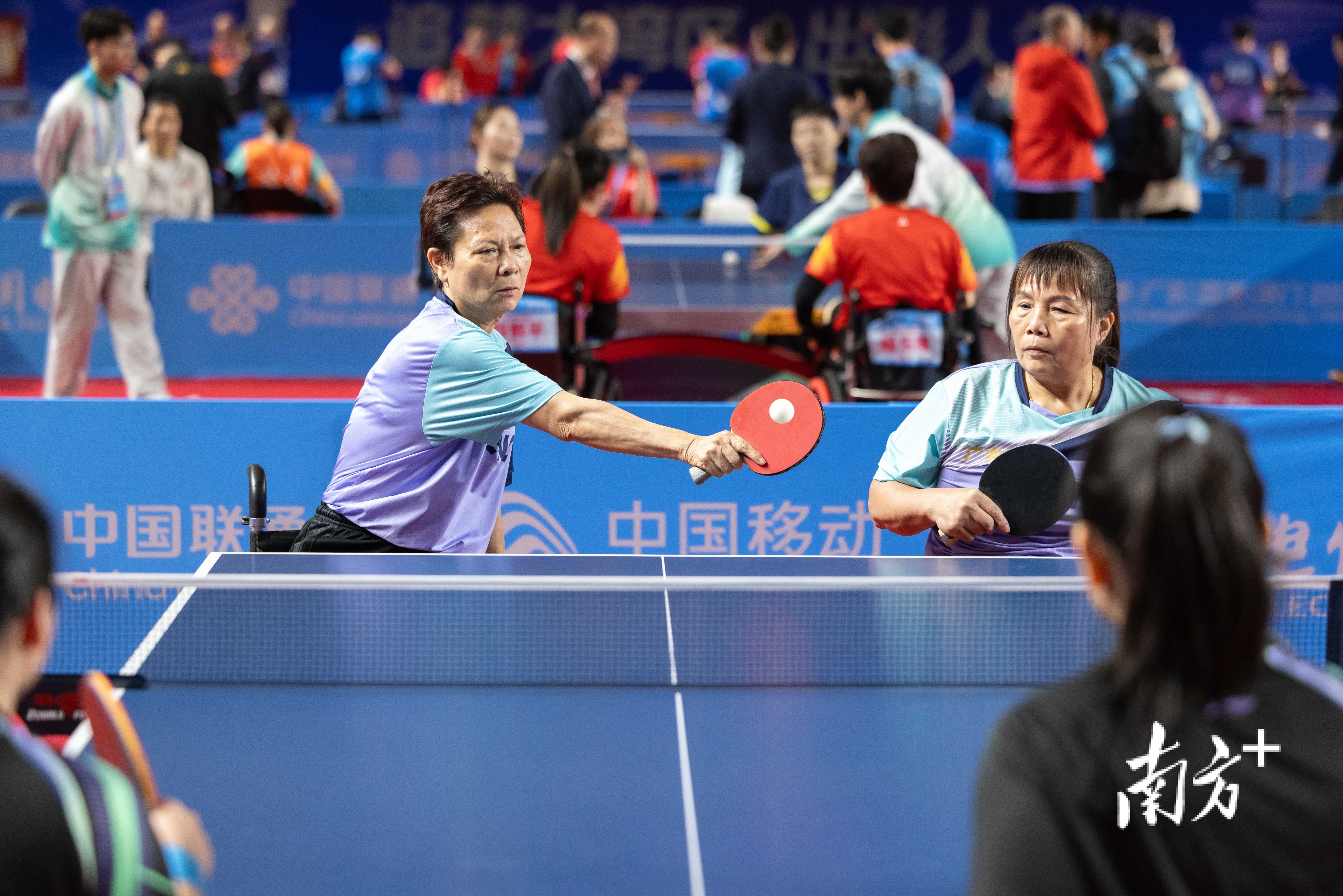 黄丽明(左)击球。