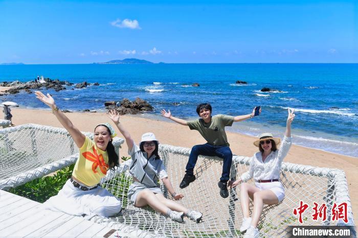6月8日，华侨大学“海外新声代”工作室成员在三亚天涯海角游览区合影。　(海南省国际文化交流中心 供图)