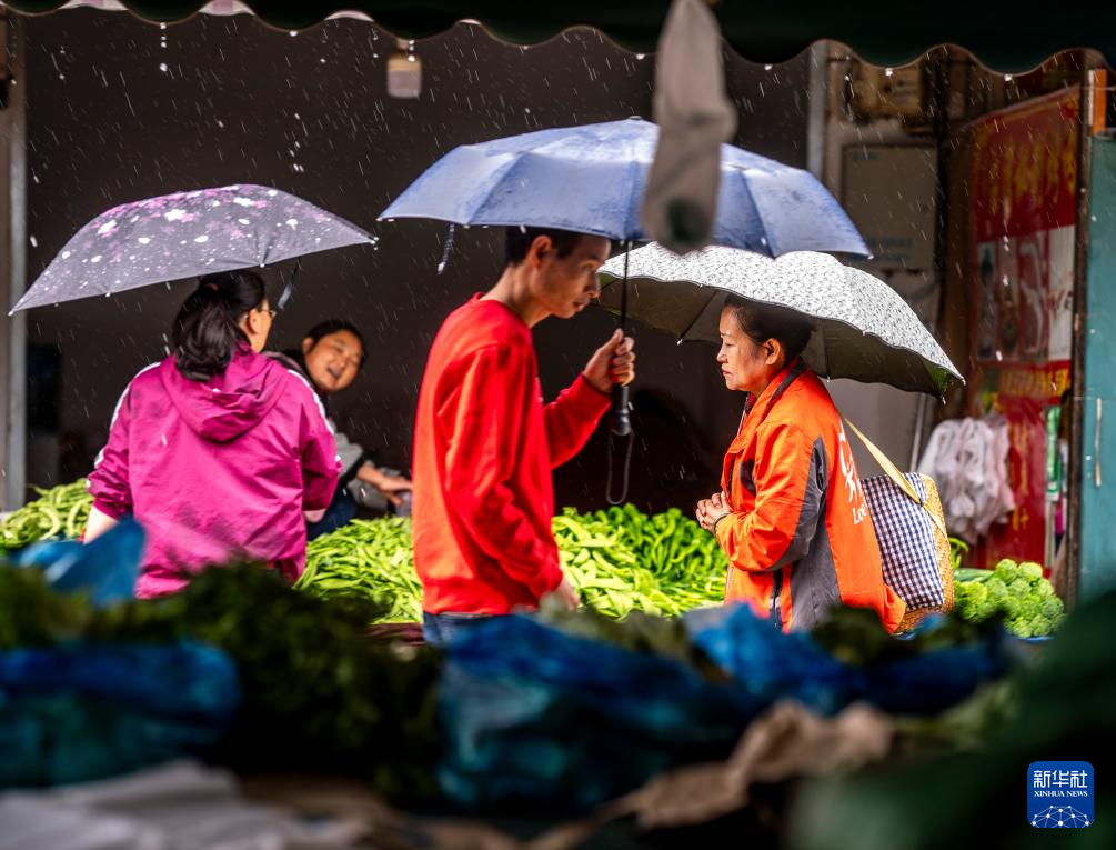 王兰兰(右一)在昆明市五华区一家菜市场为爱心食堂采购食材(5月28日摄)。