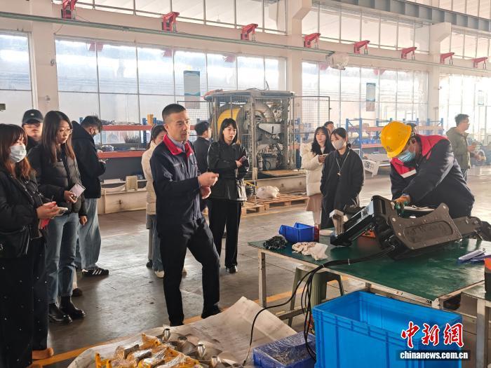 山东未来机器人有限公司厂区内,项目部总监姜立斌向采访团介绍工人作业细节。中新网记者 刘越 摄