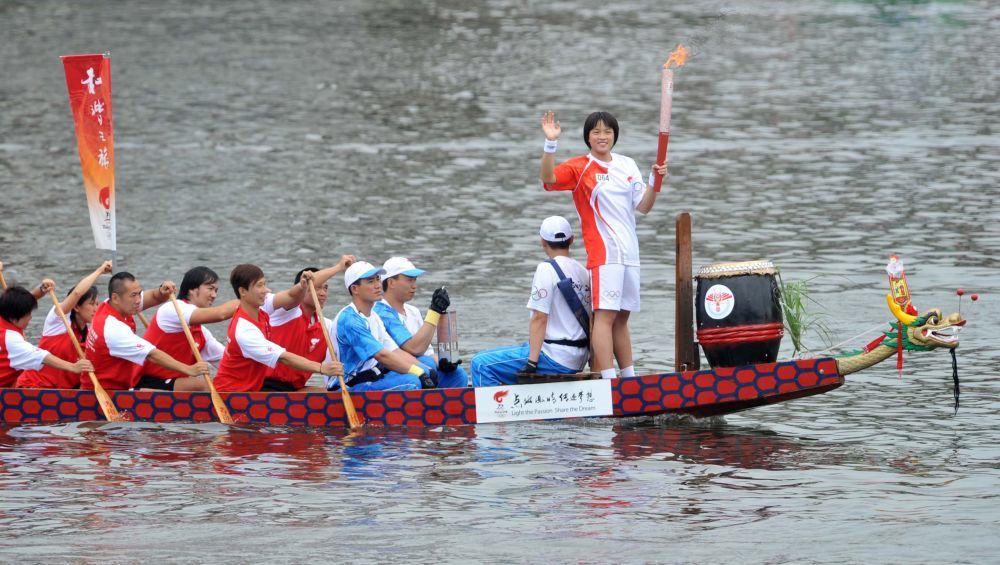 ↑火炬手、香港游泳运动员施幸余乘坐龙舟进行北京奥运会圣火传递（2008年5月2日摄）。