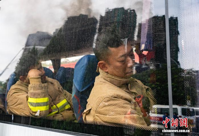 图为轮替的消防员短暂休息。　中新社记者 侯宇 摄