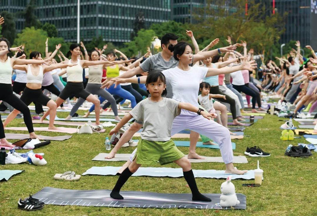 2025年6月14日,重庆。瑜伽爱好者们在老师的带领下练习瑜伽。(图/周毅/中新社)