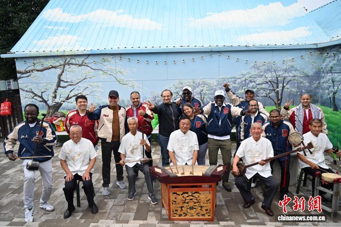 图为学员在皋兰什川古梨园与当地民俗文化表演人员合影留念　中新社记者　九美旦增　摄