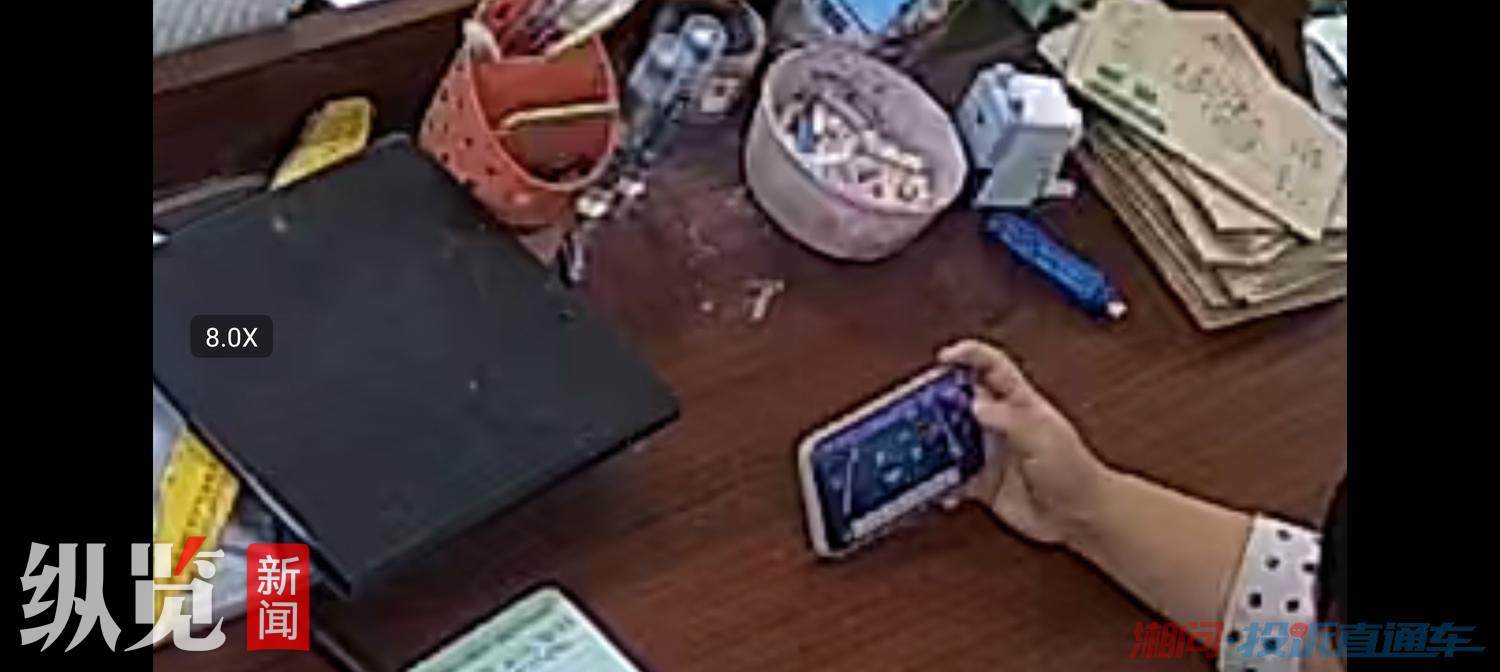 投诉网帖所附图片显示一名女子坐在讲台前正在看网络游戏。(来源/网络)