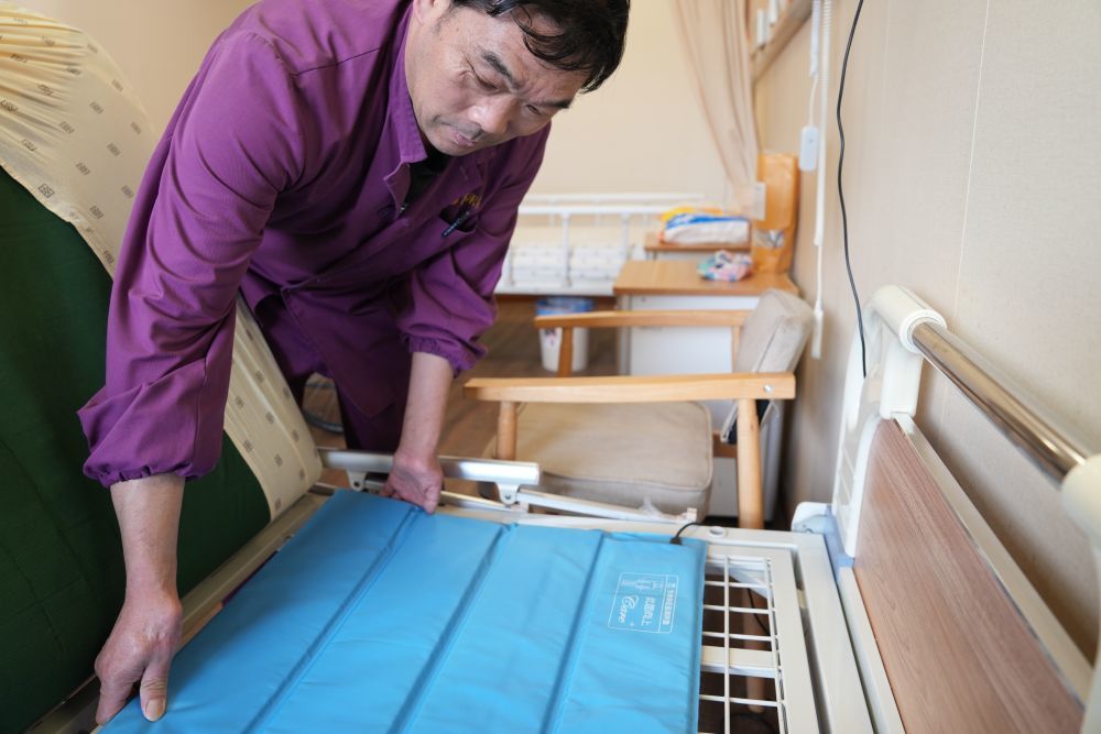 4月8日,在江苏无锡滨湖区一养老院,工作人员为老人用的床铺铺设生命体征监测床垫。这种床垫可以监测卧床老人的呼吸和心率,实时显示数据,方便护理人员及时了解老人情况。