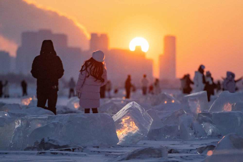 2024年1月7日，在封冻的松花江哈尔滨段，游客在“钻石海”欣赏日落美景。