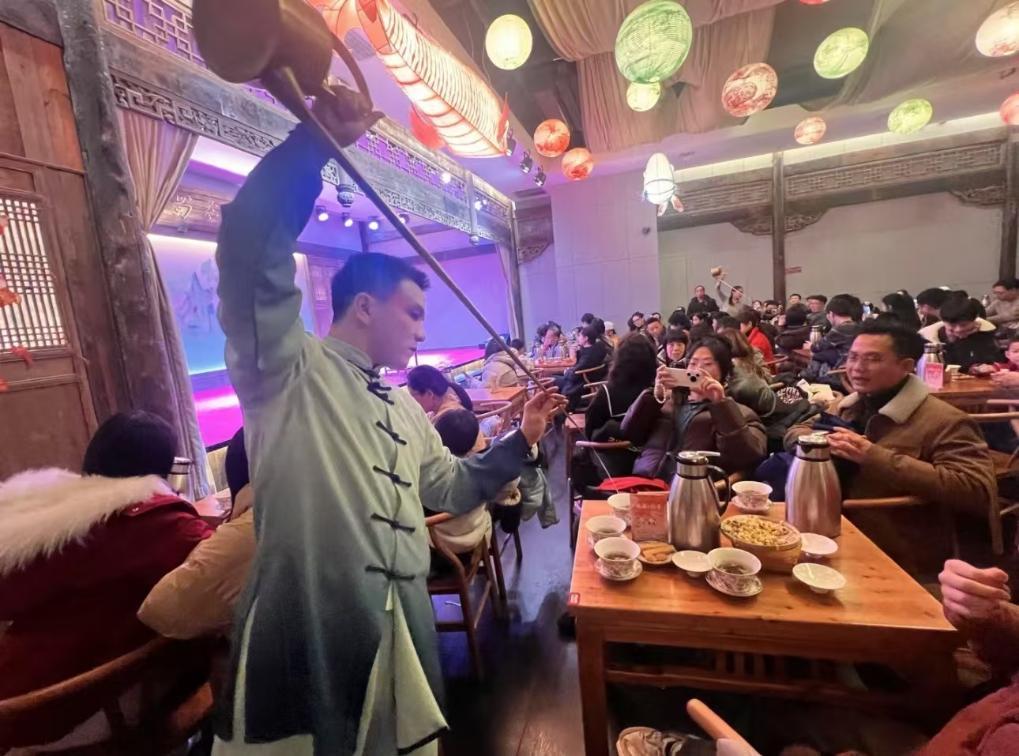1月31日，游客在四川成都的茶馆体验盖碗茶表演互动。新华社发