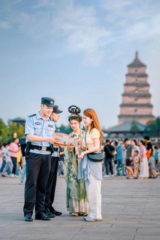 民警在大雁塔景区为来往游客宣传电信网络诈骗防范指南 摄影/龙云