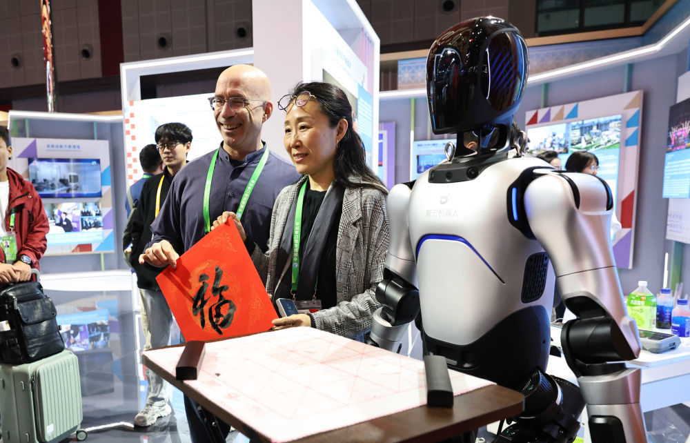 2025年11月8日,嘉宾在中国国家馆获赠由机器人书写的书法“福”字。当日是第八届进博会首个社会观众日,30余名外籍人才及家属赴国家会展中心(上海)参加“外籍人才看进博”主题活动,参观中国馆和主宾国家馆等特色展区,直观感受中国的开放与创新魅力。