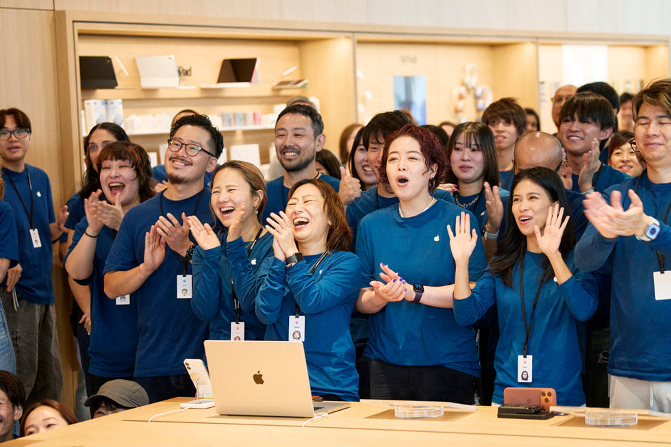 Apple 银座零售店内，团队成员在鼓掌庆贺。