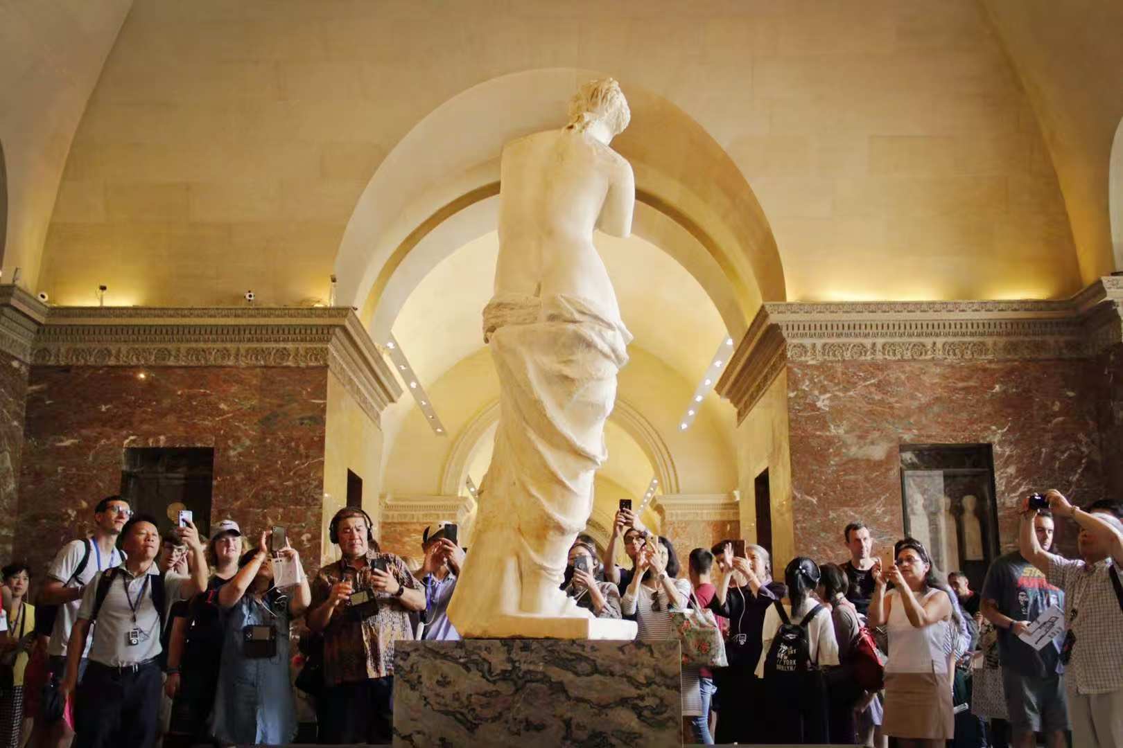 游客参观卢浮宫三宝之一的大理石雕塑《米洛斯的维纳斯》(又称《断臂维纳斯》) 观察者网