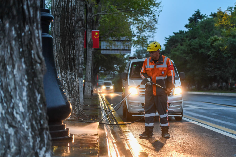 10月1日,环卫工人在吉林省长春市朝阳区新民大街清扫人行步道。新华社记者 张楠 摄