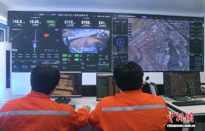 图为李伟豪(右)和同事在操控无人矿卡。中新网记者 孙亭文 摄