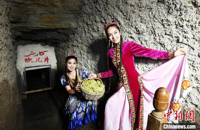 身着传统服饰的当地群众在坎儿井打卡拍照。吐鲁番市融媒体中心供图