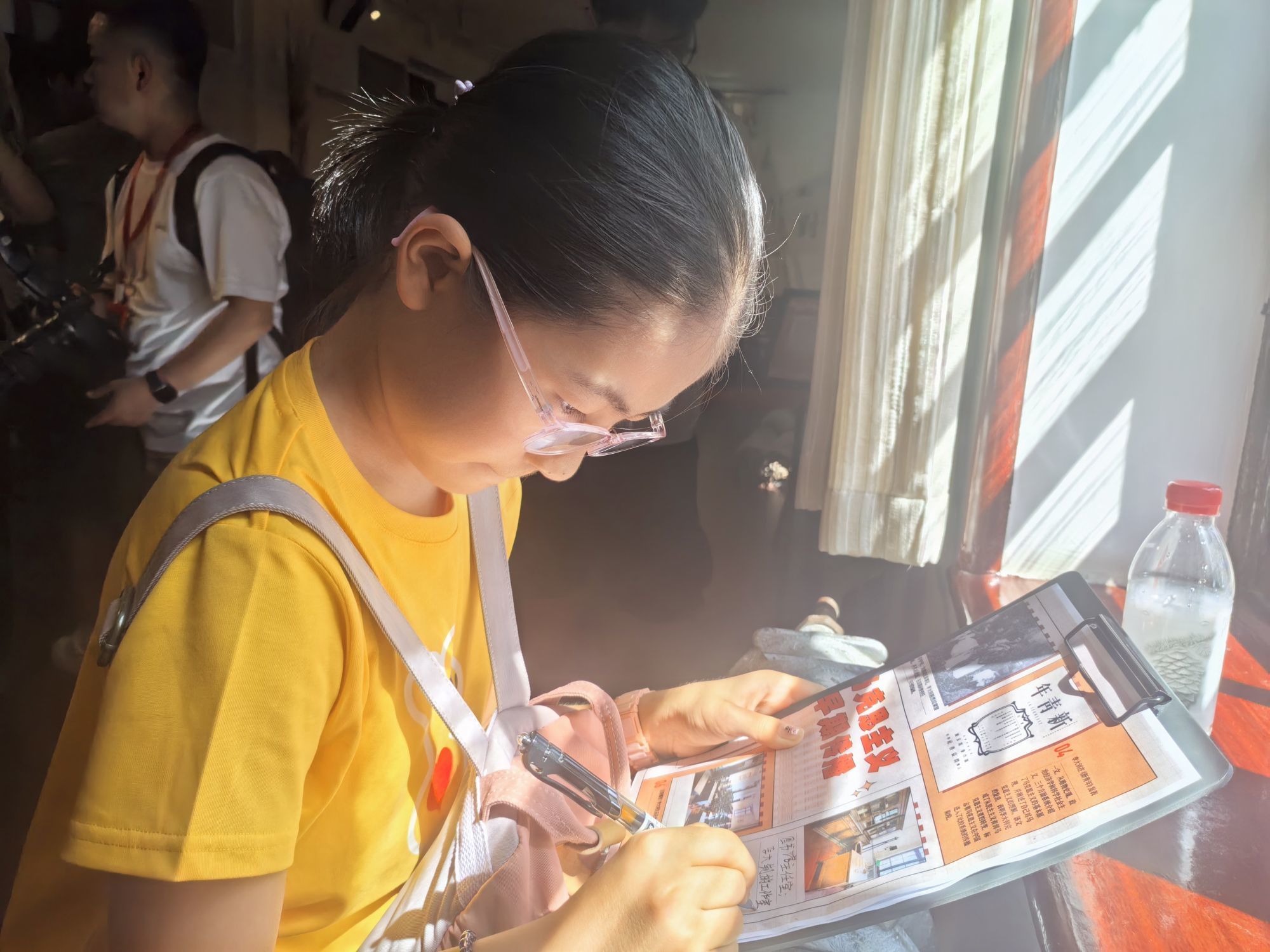 在北大红楼馆区，小朋友正在《北大红楼研学手册》上记录自己的“打卡”感受。