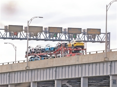 针对美国新关税政策，加拿大对美国汽车对等征收25%关税措施已于日前生效。图为近日，在加拿大安大略省尼亚加拉瀑布市加美边境地带，一辆满载的汽车运输车通过刘易斯顿—昆斯顿桥开往加拿大。　　邹  峥摄（新华社发）