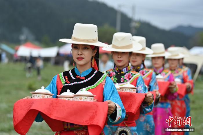 图为身穿“三格毛”的藏族姑娘为百岁老人端“藏王宴”菜品　九美旦增　摄