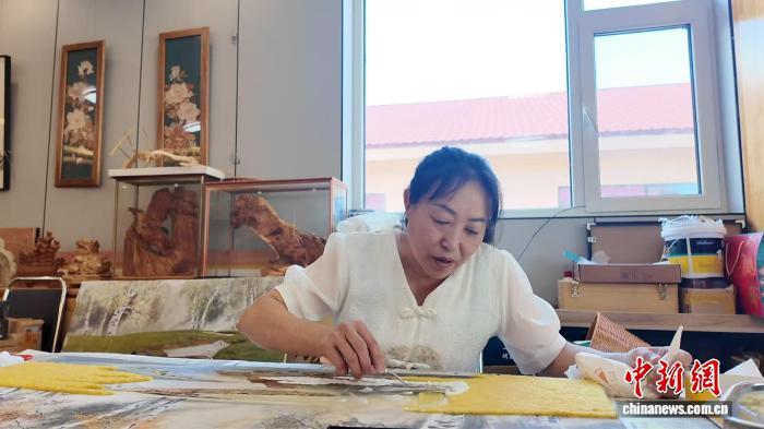 图为周艳辉正在制作树皮画。崔博群 摄
