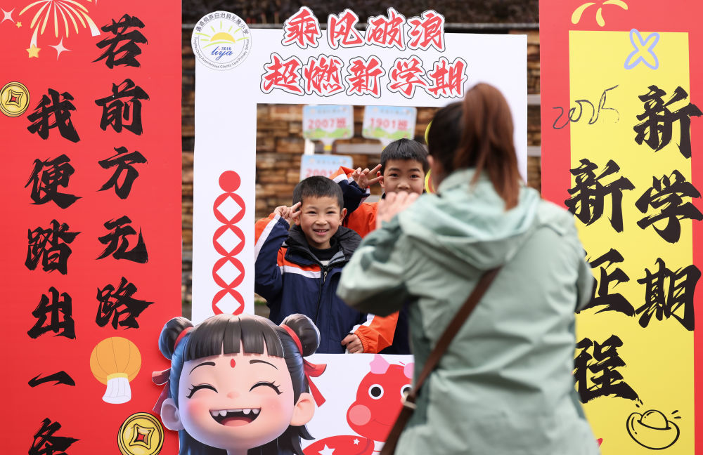 2月16日，在湖南省怀化市通道侗族自治县礼雅小学，学生在展板前留影。新华社发（粟勇主 摄）