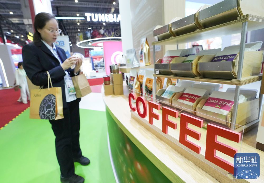 ↑ 11月7日，参观者在第八届进博会国家展布隆迪馆了解一款咖啡。新华社记者 任鹏飞 摄