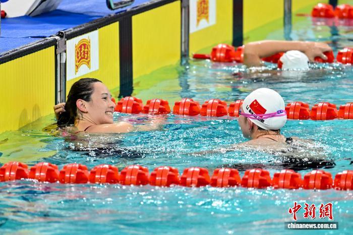 11月13日晚，第十五届全国运动会女子200米自由泳决赛在深圳大运中心游泳馆开赛，香港选手何诗蓓夺得冠军。图为何诗蓓(左)与李冰洁交流。中新社记者韦亮摄