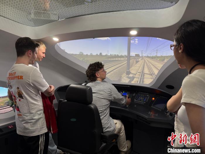 20日，德国伯乐中文合唱团的师生在成都体验高铁模拟驾驶。　 中新网记者 贺劭清 摄