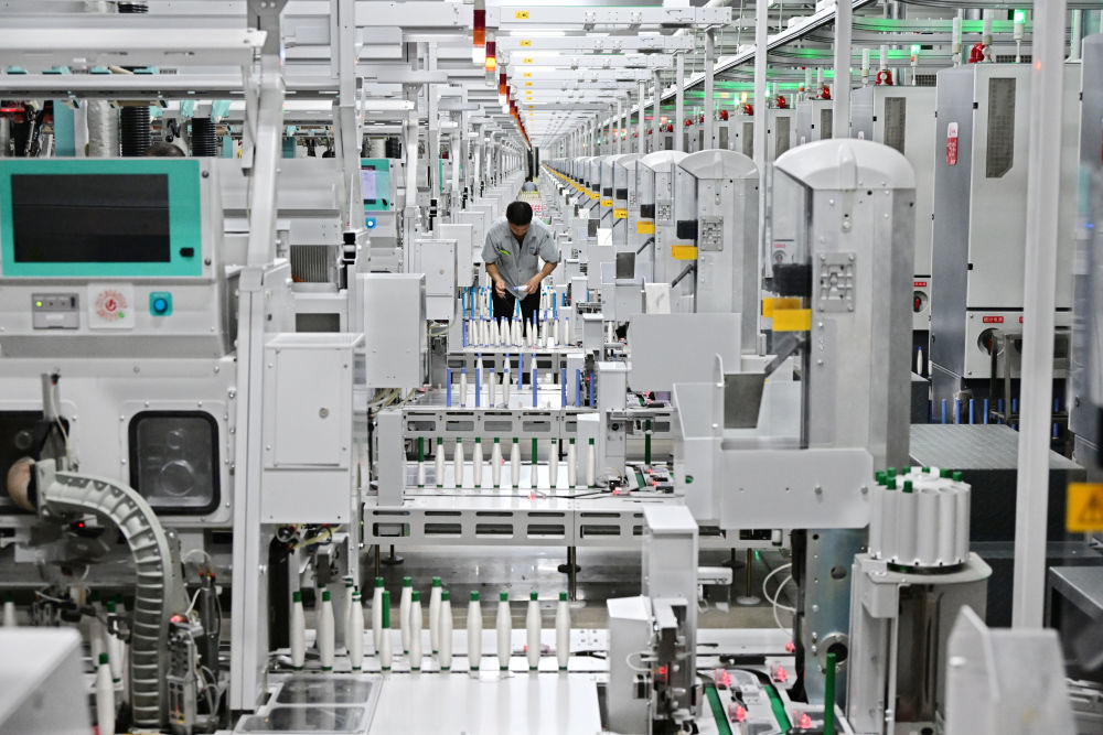 3月25日，山东即墨一家智慧纺纱企业的技术人员在维护全自动络筒生产设备。新华社记者 李紫恒 摄