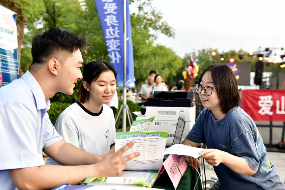 在山东省滨州市惠民县孙武广场,人社局的工作人员向市民介绍社保证明查询相关服务(2025年8月25日摄)。新华社记者 郭绪雷 摄