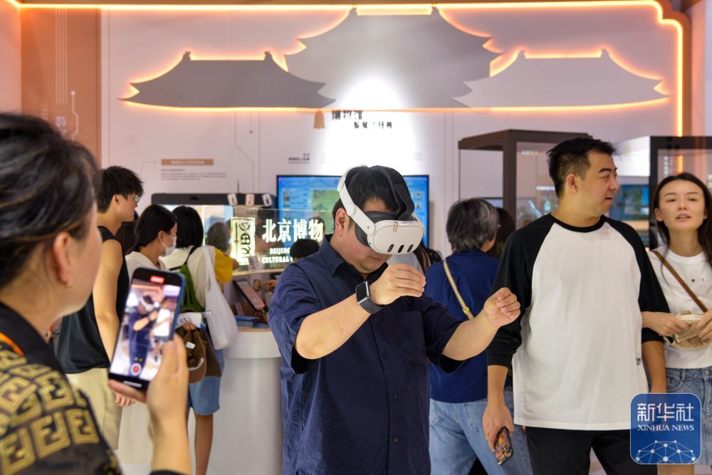 ↑ 9月13日,在北京首钢园,参展者(中)在2025年服贸会文旅服务展馆北京市文物局展台体验《看·见殷商》MR沉浸式观展。