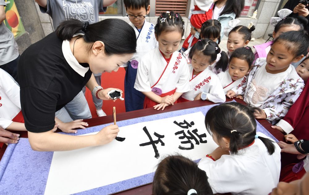 2025年5月31日，北京市朝阳区青年路社区组织居民开展“情满邻里 粽香传情”邻里共度端午节活动，社区里的孩子们和家长一起参加了书法、文艺表演、香囊制作、阅读等活动。新华社记者 李欣 摄