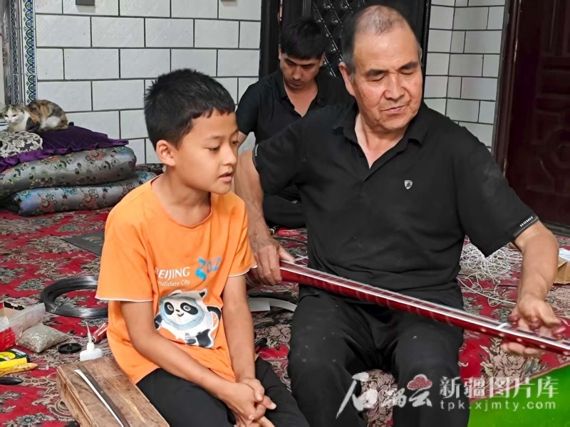 小朋友观看努尔冬・司马义制作乐器。石榴云/新疆日报记者 宋海波摄