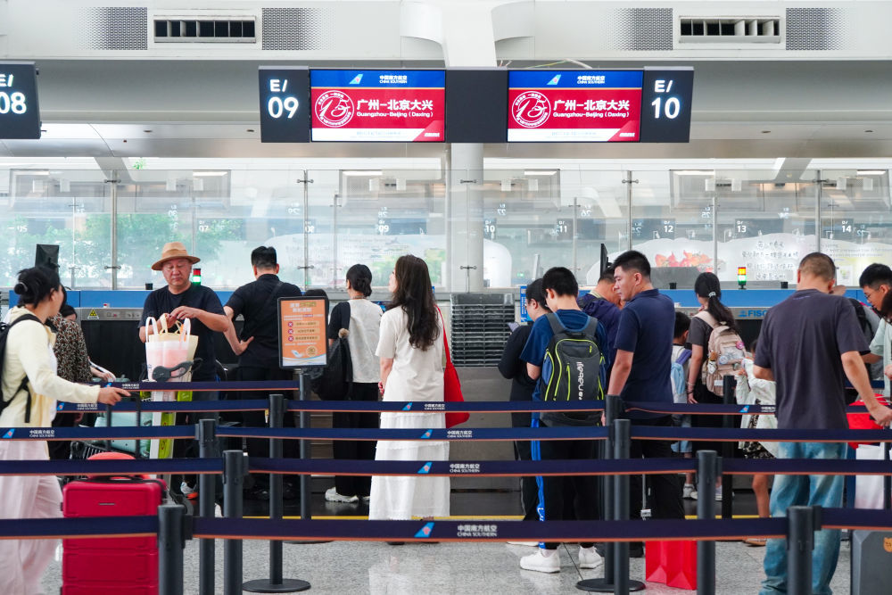 7月8日,乘客在广州白云机场南航值机柜台办理手续。新华社发