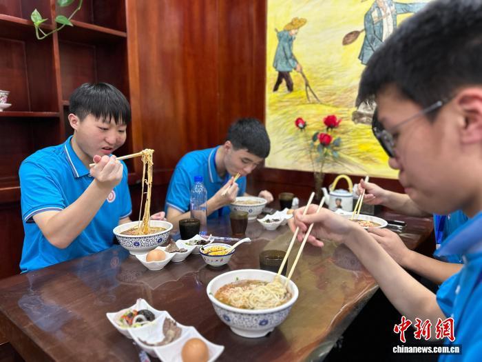 图为港青品尝兰州牛肉面 王牧雨 摄