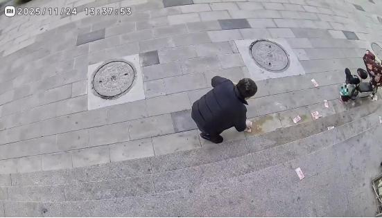 当事人捡起散落的现金。图/社交媒体截图