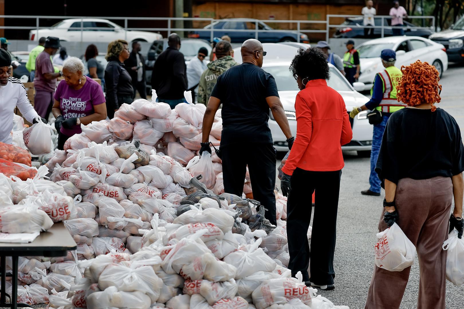 ▲当地时间2025年11月19日,美国佐治亚州亚特兰大,志愿者们在“感恩节火鸡派送”活动中准备并分发食物袋 图据视觉中国