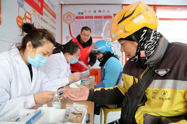 2025年3月5日，志愿者在山东省枣庄市市中区一工会驿站为外卖员免费测量血糖。新华社发（王海楠摄）