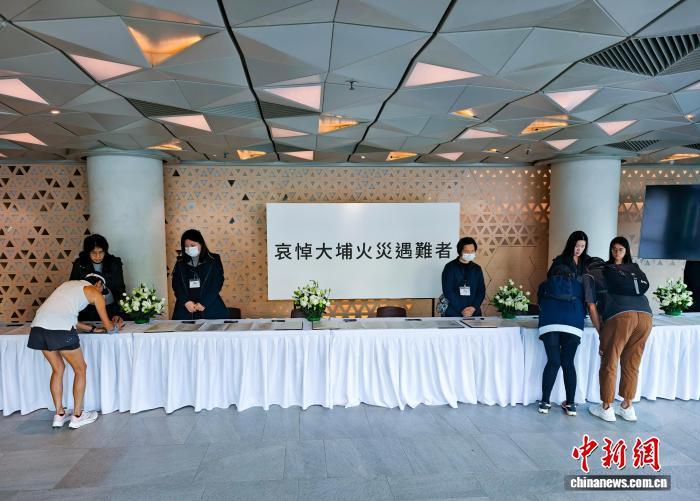 11月29日,香港民众前往位于北角社区会堂的一个吊唁处,在吊唁册上写下寄语,向大埔宏福苑火灾罹难者表达哀思。香港特区政府民政事务总署自当天起至12月1日,在全香港18区设置吊唁处,供市民进行吊唁。 中新社记者 侯宇 摄