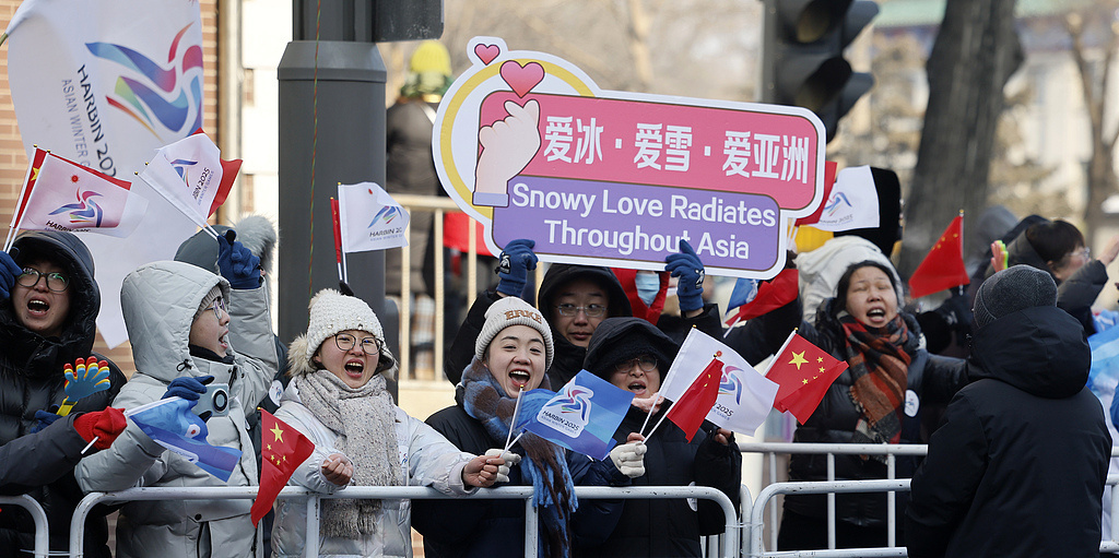 △2025年2月3日，第九届亚冬会火炬传递活动在哈尔滨市进行，各界群众在路旁为火炬手加油。（图自视觉中国）