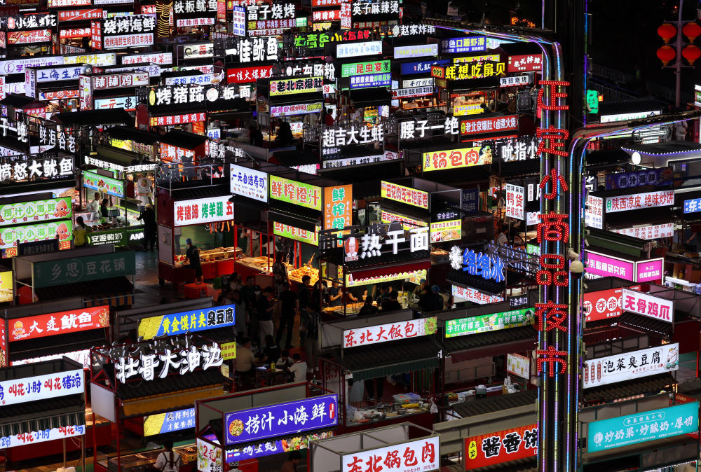 5月15日,游客在河北省正定县小商品夜市品尝美食。新华社记者 杨世尧 摄