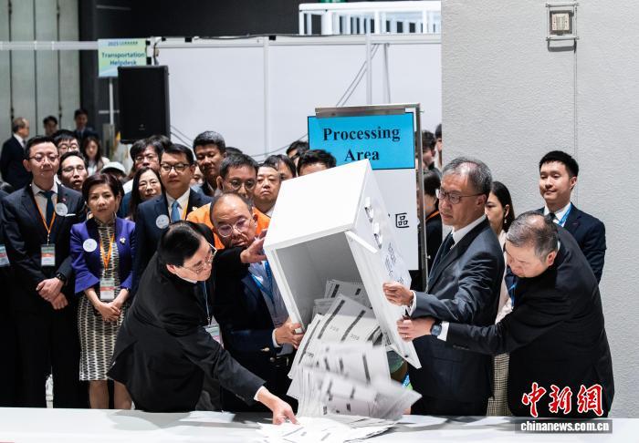 12月7日23时30分许，香港特区第八届立法会选举投票结束，随即开始点票工作。图为香港特区政府政制及内地事务局局长曾国卫(前排左二)、香港特区选举管理委员会主席陆启康(前排右二)等在位于香港会议展览中心的中央点票站倒出选举委员会界别投票箱中的选票。　中新网记者 侯宇 摄