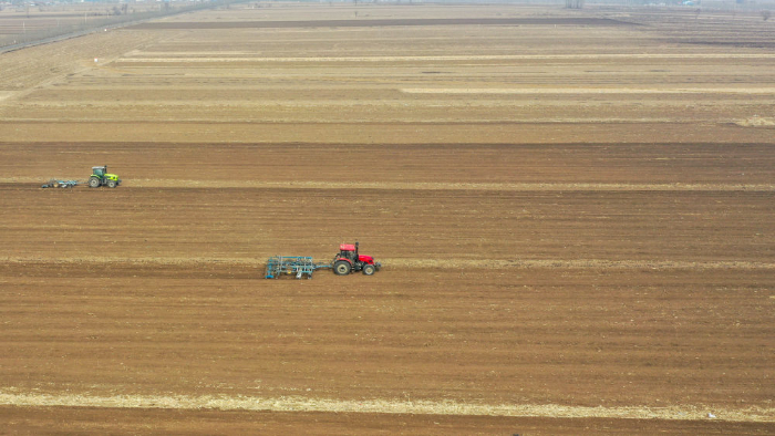 在吉林省公主岭市朝阳坡镇东兴村，公主岭市军平种植家庭农场农民驾驶农机整理土地，为春耕做准备（2025年4月9日摄，无人机照片）。新华社记者张楠摄