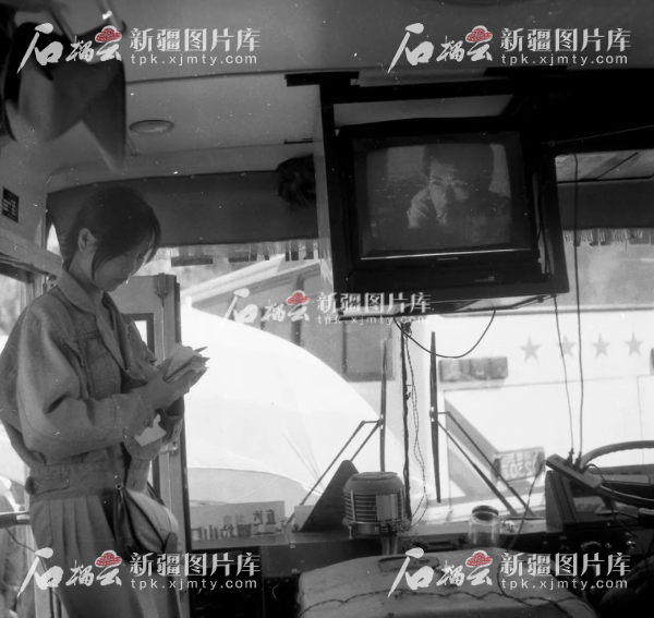 20世纪90年代,在博乐开往阿拉山口的客车上,售票员正在售票。博尔塔拉蒙古自治州党委宣传部供图