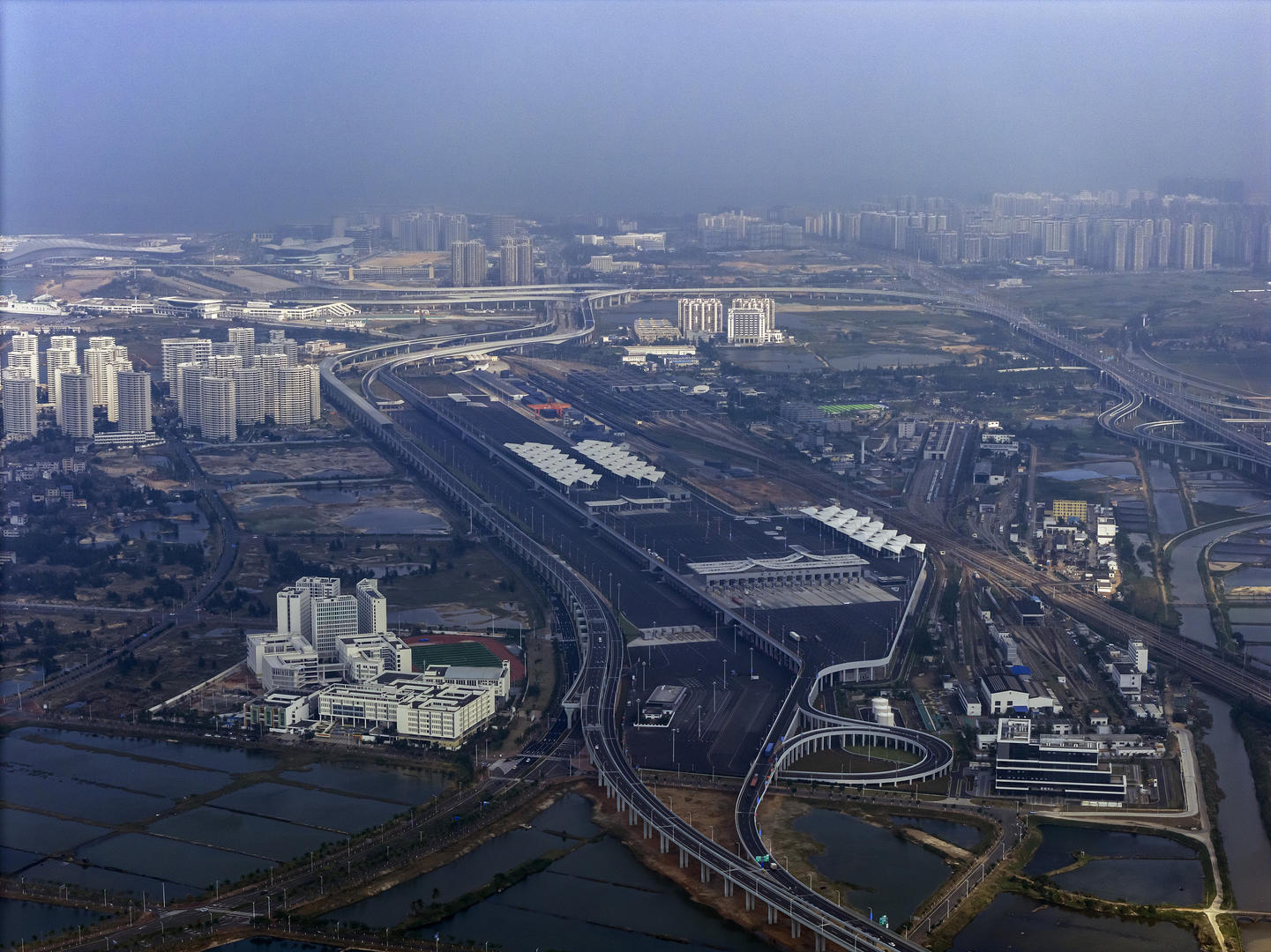 ▲12月18日上午10时开始,海南自贸港“二线口岸”海口新海港、南港离岛货车查验场、海关查验场封关正式启动,第一批通关货物车辆出关(航拍) 图据视觉中国
