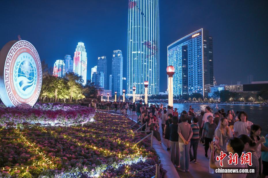 2025年上海合作组织峰会8月31日至9月1日在天津举行。资料图：8月28日晚，市民和游客漫步天津海河畔，参观“2025上海合作组织峰会”主题花坛。 中新社记者 佟郁 摄