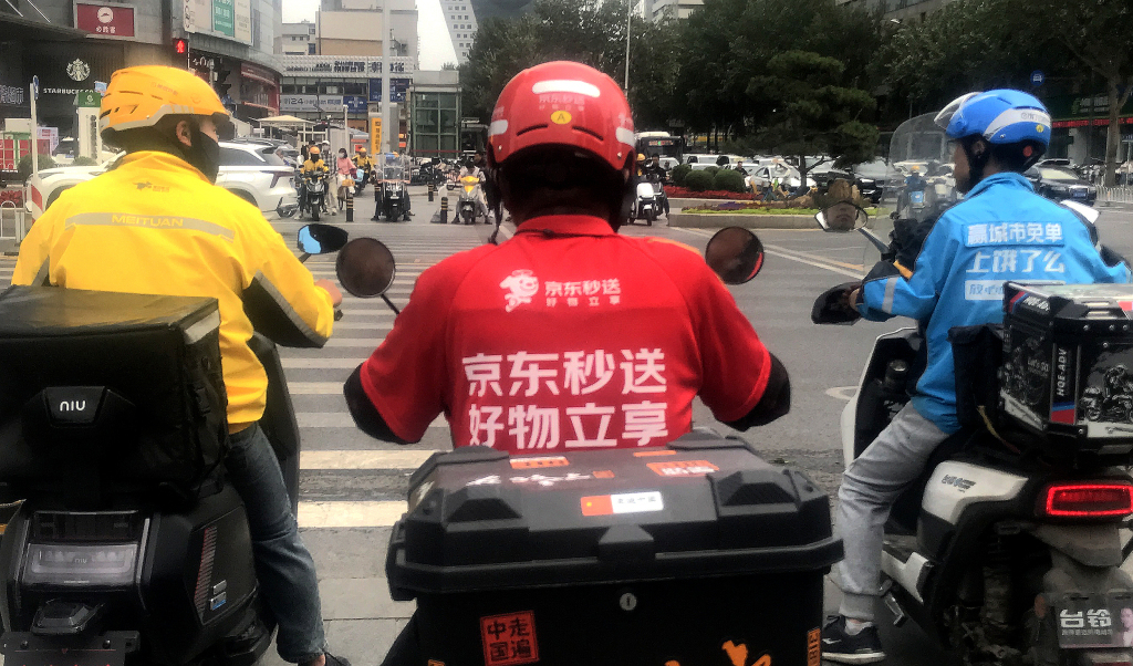 2025年6月5日,辽宁省沈阳市,京东、美团、饿了么的外卖配送员在街头相遇。视觉中国 图