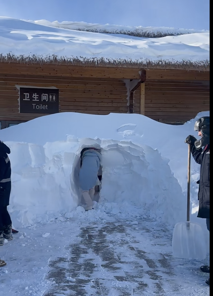 工作人员清理公厕外积雪，游客钻雪洞如厕。网络截图
